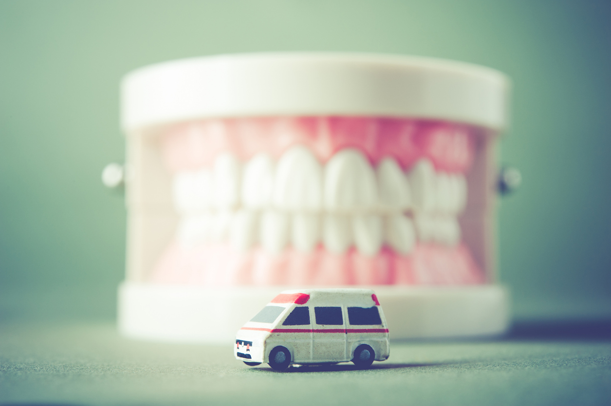 The image shows a model of teeth and miniature ambulance in the space in front of it. The images explains the most common types of dental emergencies.